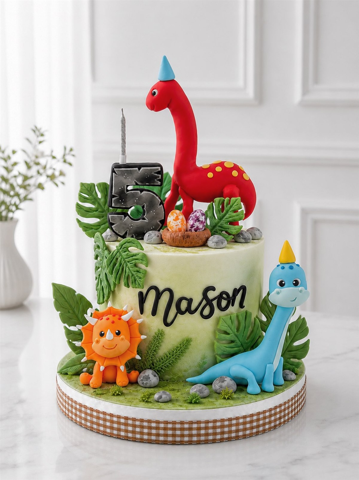 Kue dinosaurus Mason dengan dinosaurus merah dan biru serta angka 5