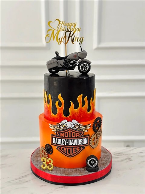 Kue motor dua tingkat hitam oranye dengan motif api, logo Harley-Davidson, dan angka 33