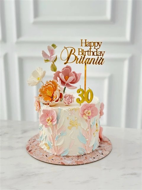 Kue bunga pastel dengan bunga pink dan peach, detail emas, dan topper ulang tahun ke-30