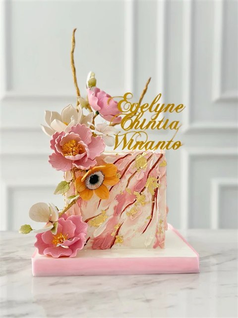 Kue tinggi marmer pink putih dengan bunga pink, putih, dan oranye serta aksen emas