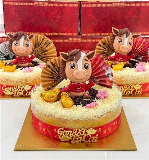 Kue hampers Imlek dengan karakter kuda, dekorasi merah emas, dan ucapan Gong Xi Fa Cai di depan kotak hadiah merah