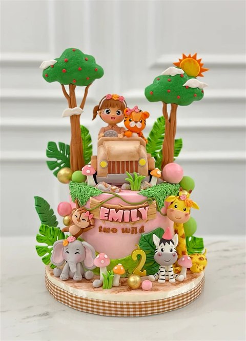 Kue jungle pink bertuliskan Emily two wild dengan jeep dan satwa.