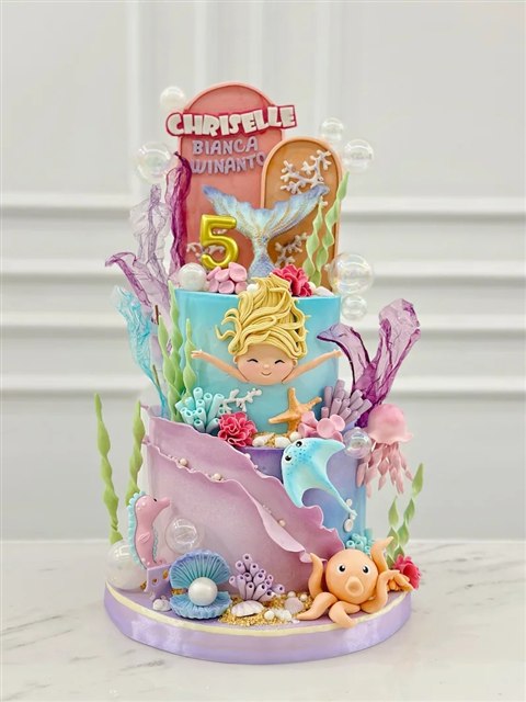 Kue mermaid turquoise dan lavender dengan figur putri duyung pirang, pari biru, gurita dan angka lima