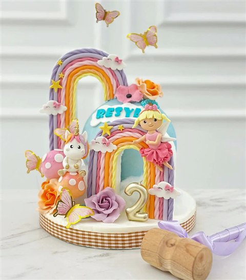 Piñata biru pastel berhias pelangi, peri, unicorn, dan kupu-kupu.